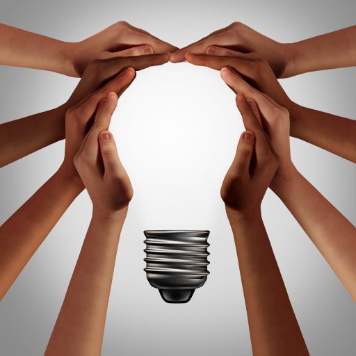 Hands coming together to form the shape of a light bulb.