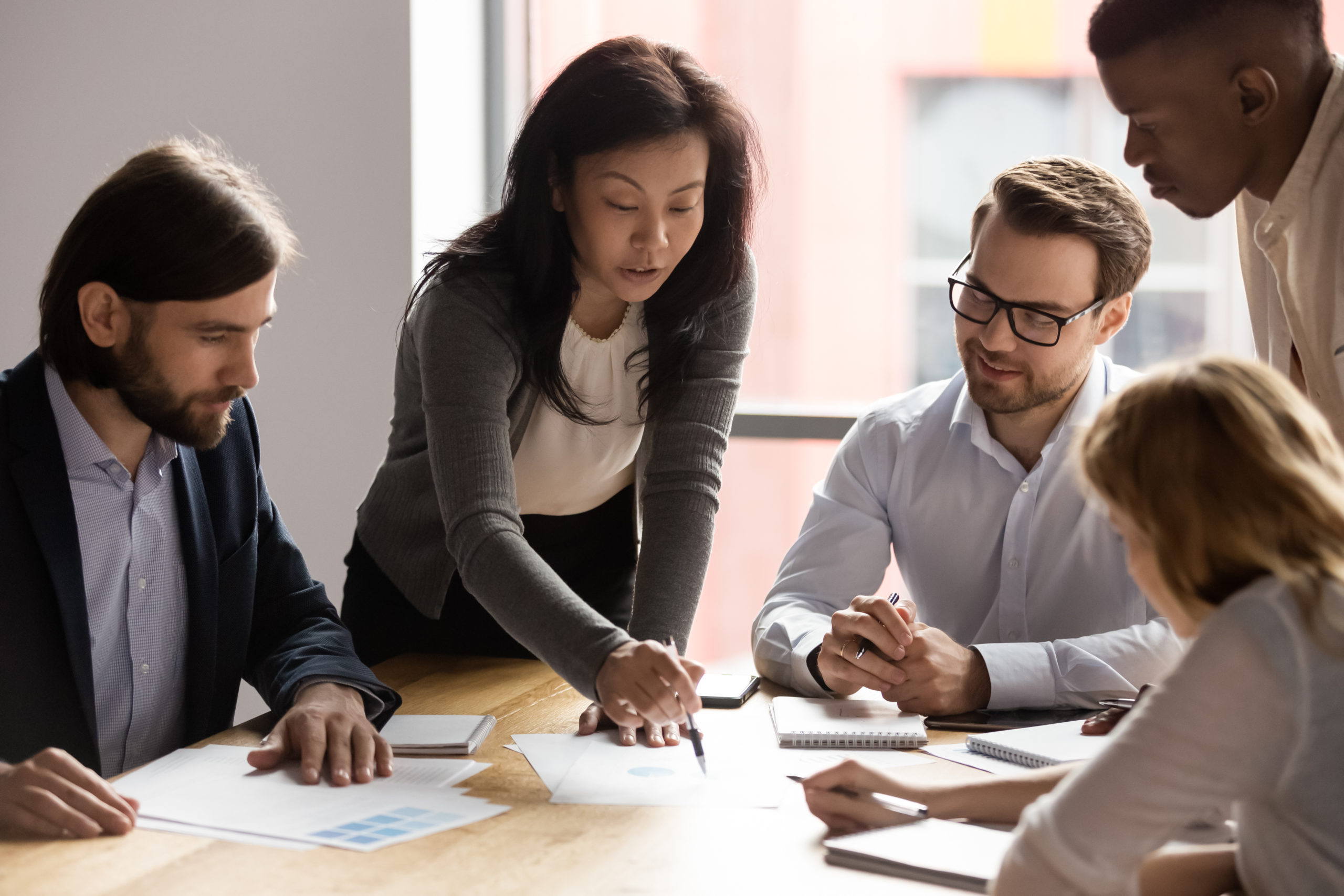 A woman business leader takes her team through a report.