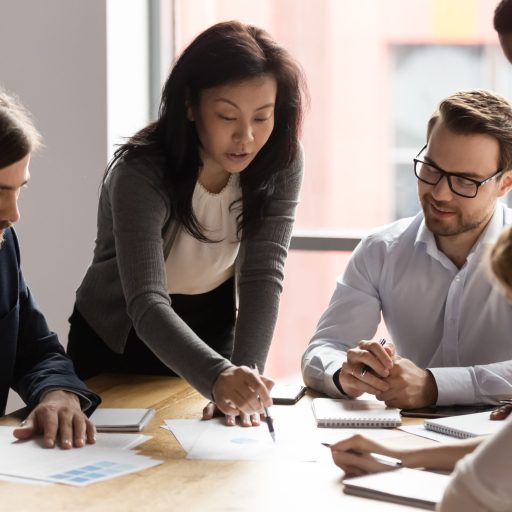 A woman business leader takes her team through a report.