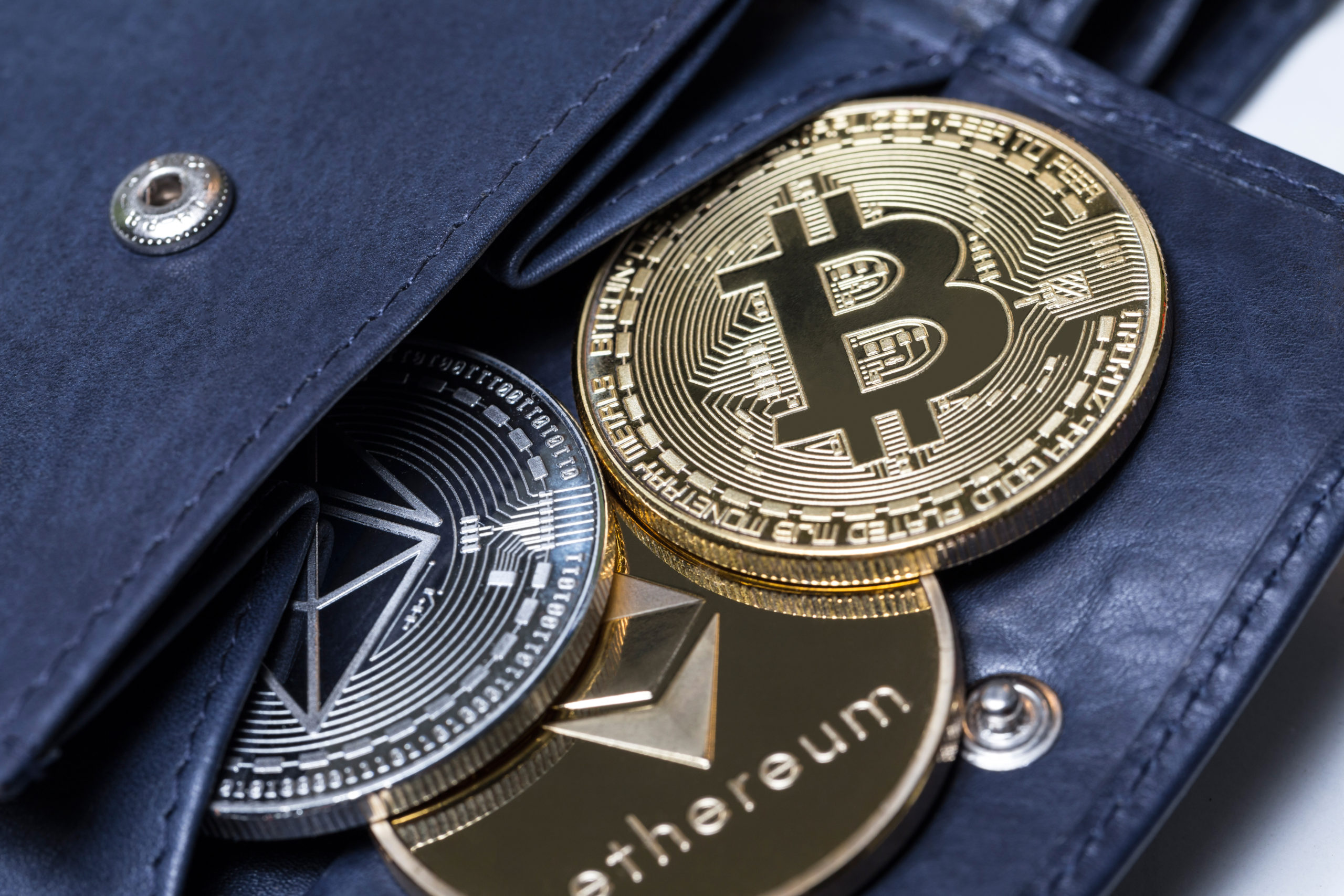 Cryptocurrency "coins" spilling out of a wallet.