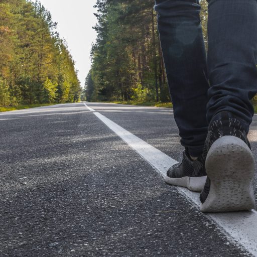 Someone takes a step forward along a forest road.