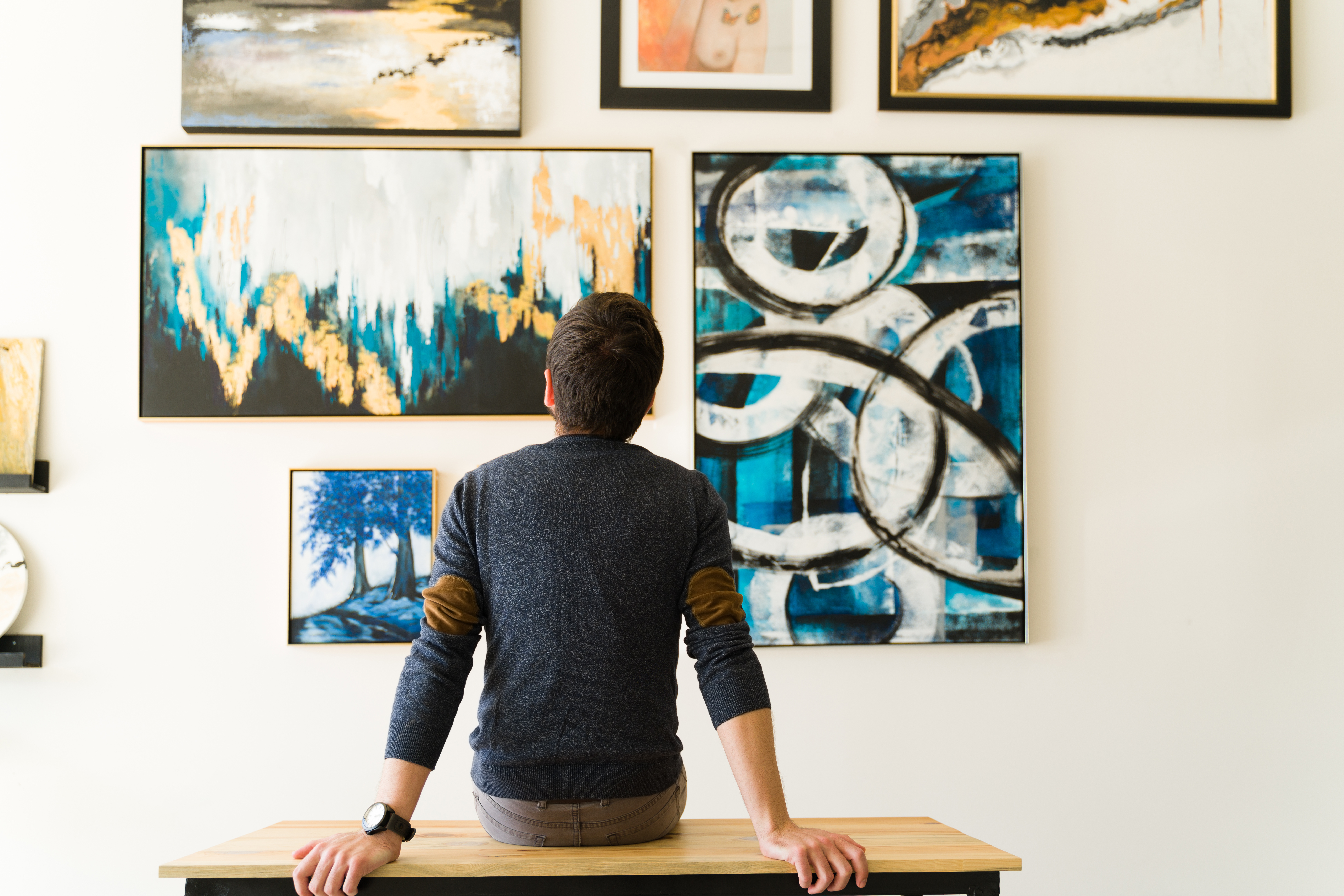 Rear view of a guy looking at an art exhibition.