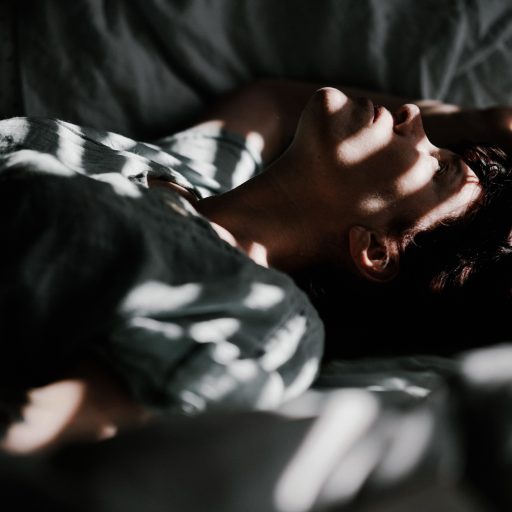 A person lying in bed lacking sleep due to daylight saving time.