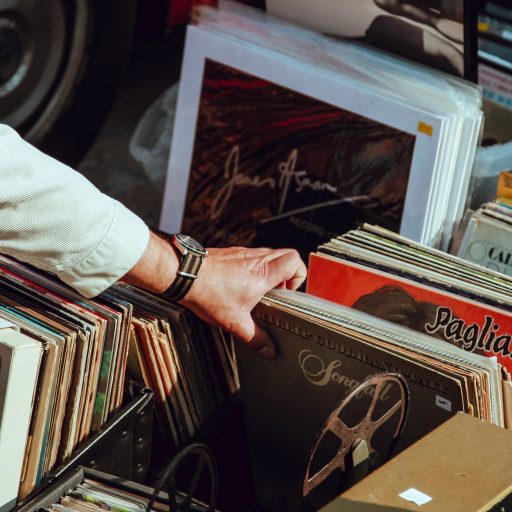 A hand flipping through a box of old records to illustrate why old people don't like new music.