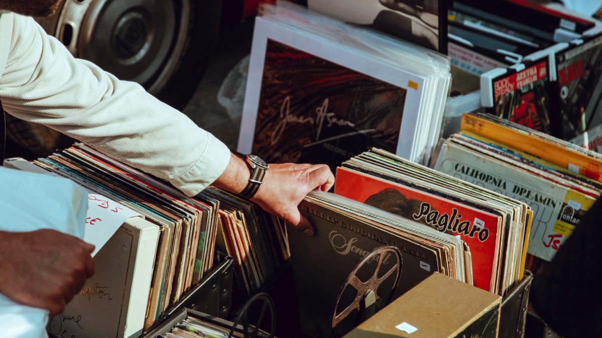 A hand flipping through a box of old records to illustrate why old people don't like new music.