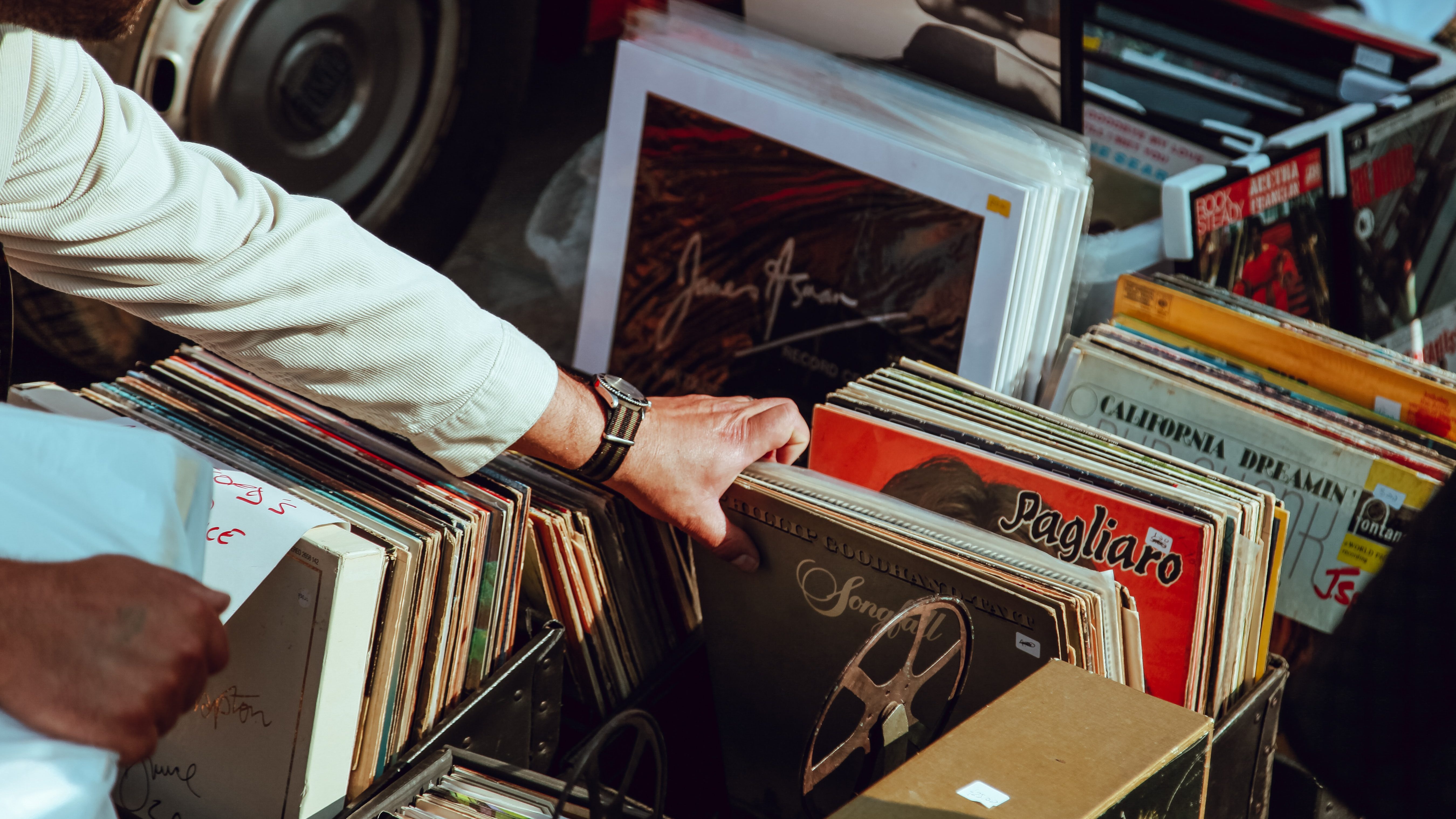 A hand flipping through a box of old records to illustrate why old people don't like new music.