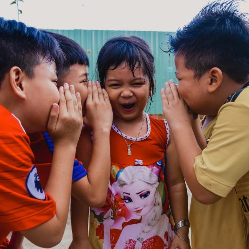 Four children gossiping illustrating that gossip is a social skill