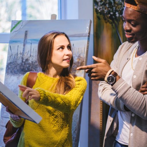 A young couple discuss a painting.