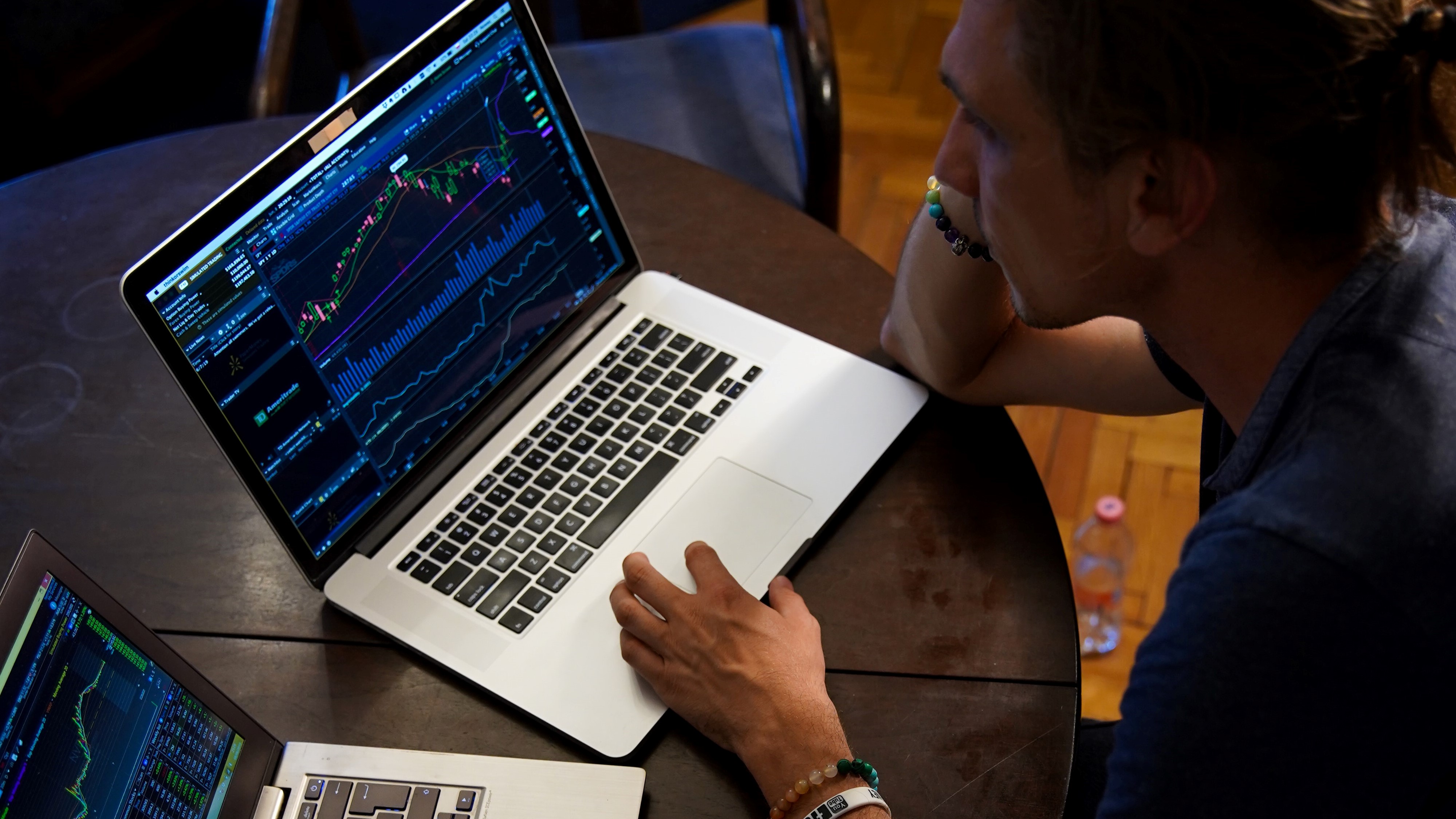 A man trading on two different laptops