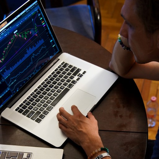 A man trading on two different laptops