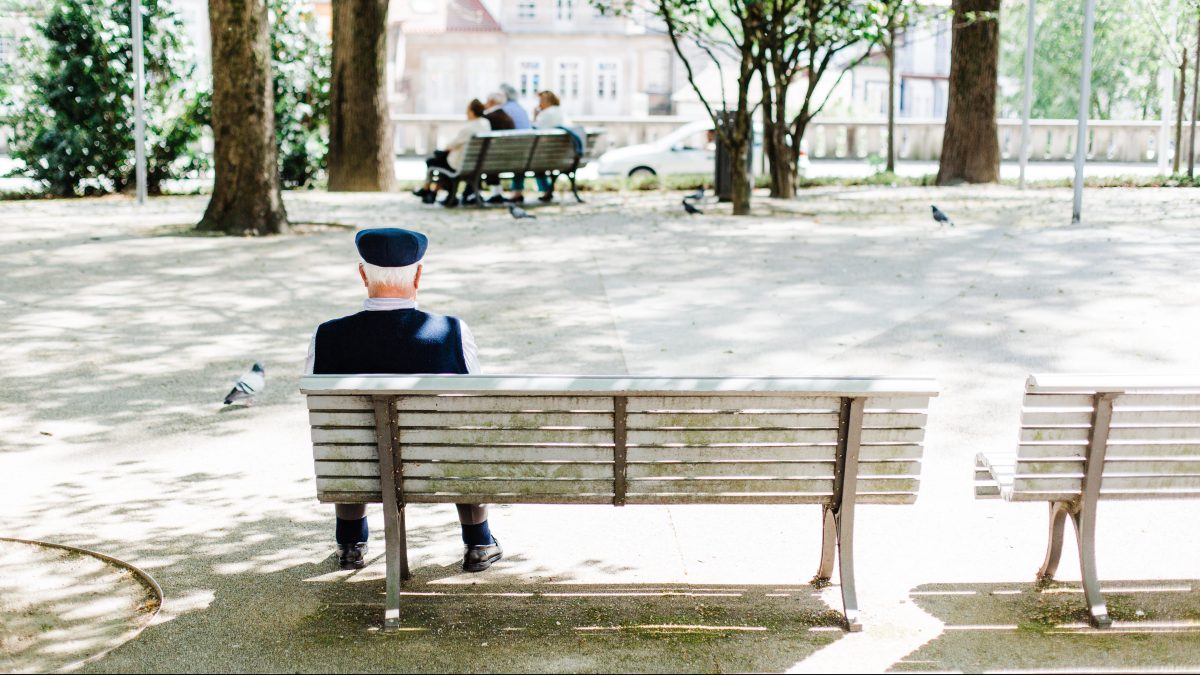 An older man sitting on a bench.
