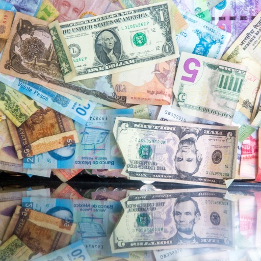 Inflation: An image of money taped to a wall and reflected by a glass surface.