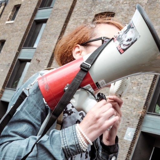 A woman holding a loudspeaker at a protest.