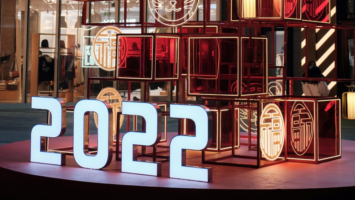 Things to be optimistic about in 2022, illustrated by a neon 2022 sign in a shopping street.