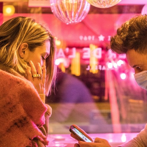 A couple sitting in a pink restaurant.