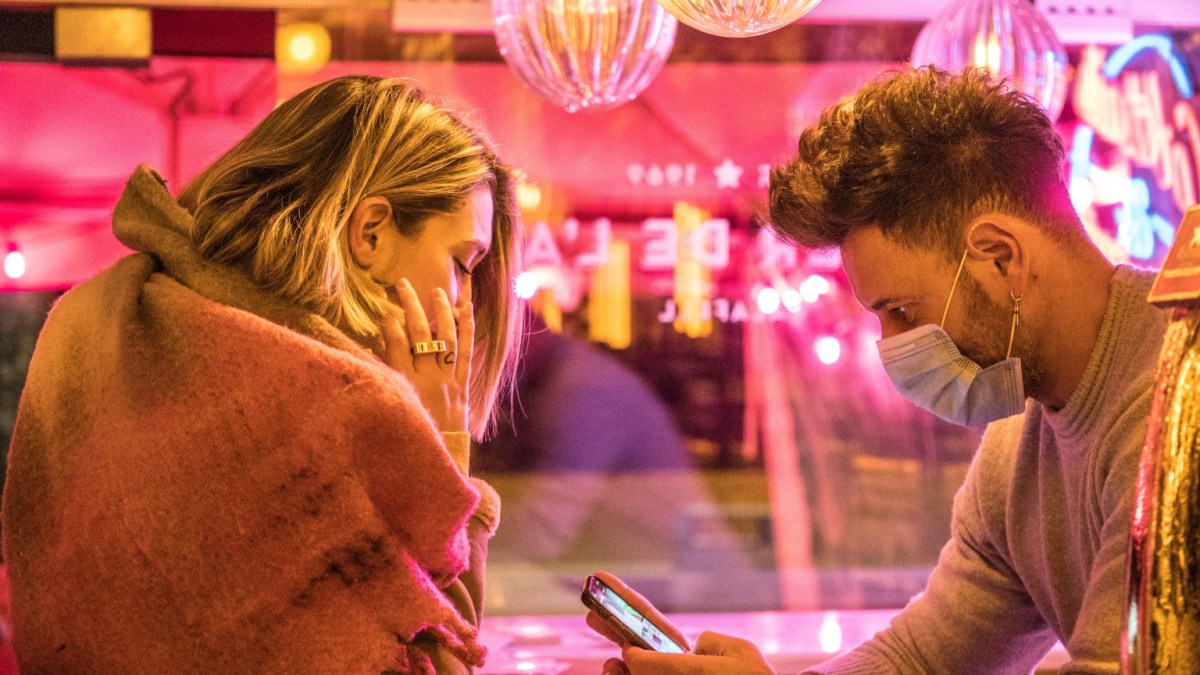 A couple sitting in a pink restaurant.