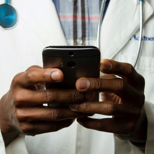 Closeup of a doctor's hands using a smartphone.