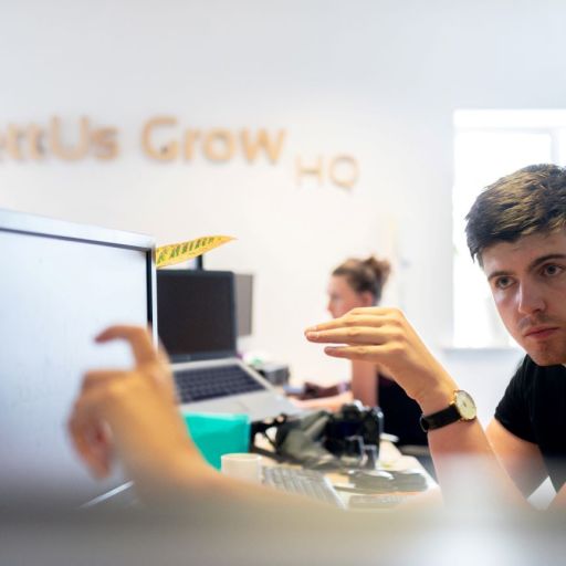 Two colleagues working on a problem in front of a computer.