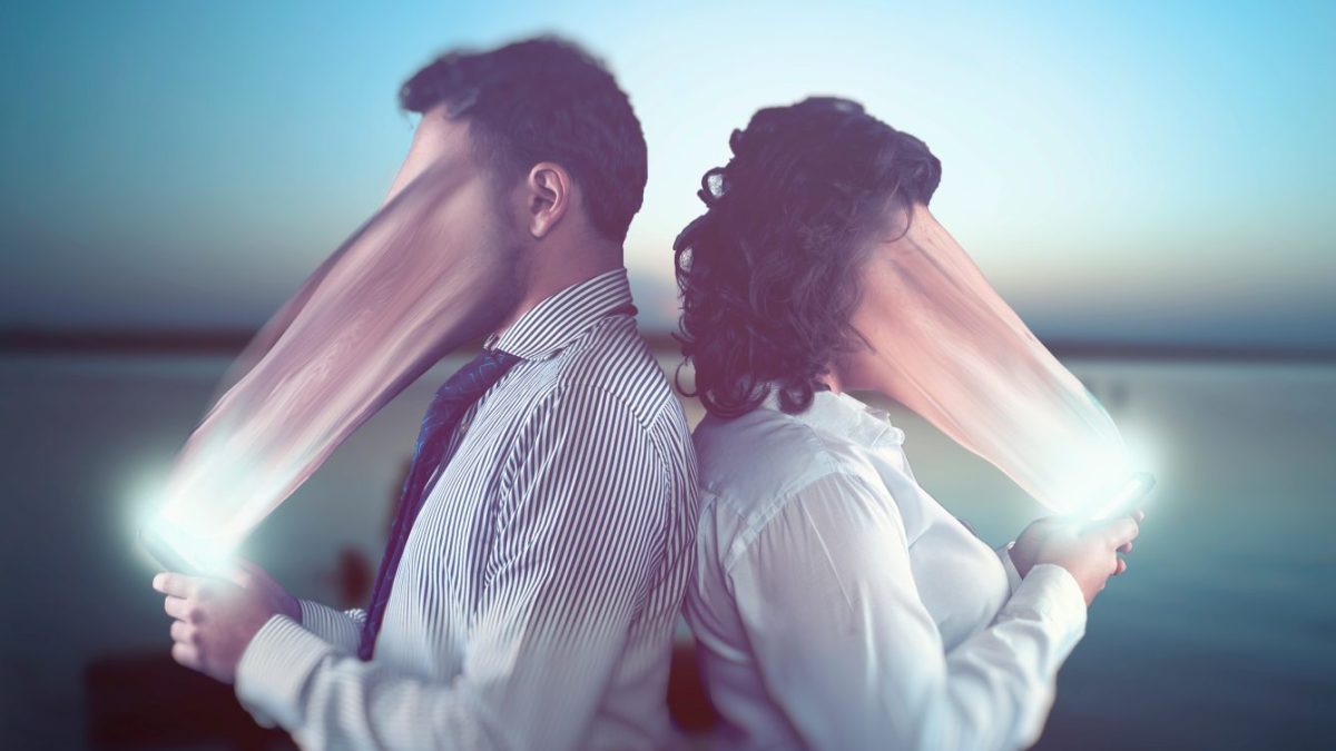 Faces of two people are being absorbed by their phones.