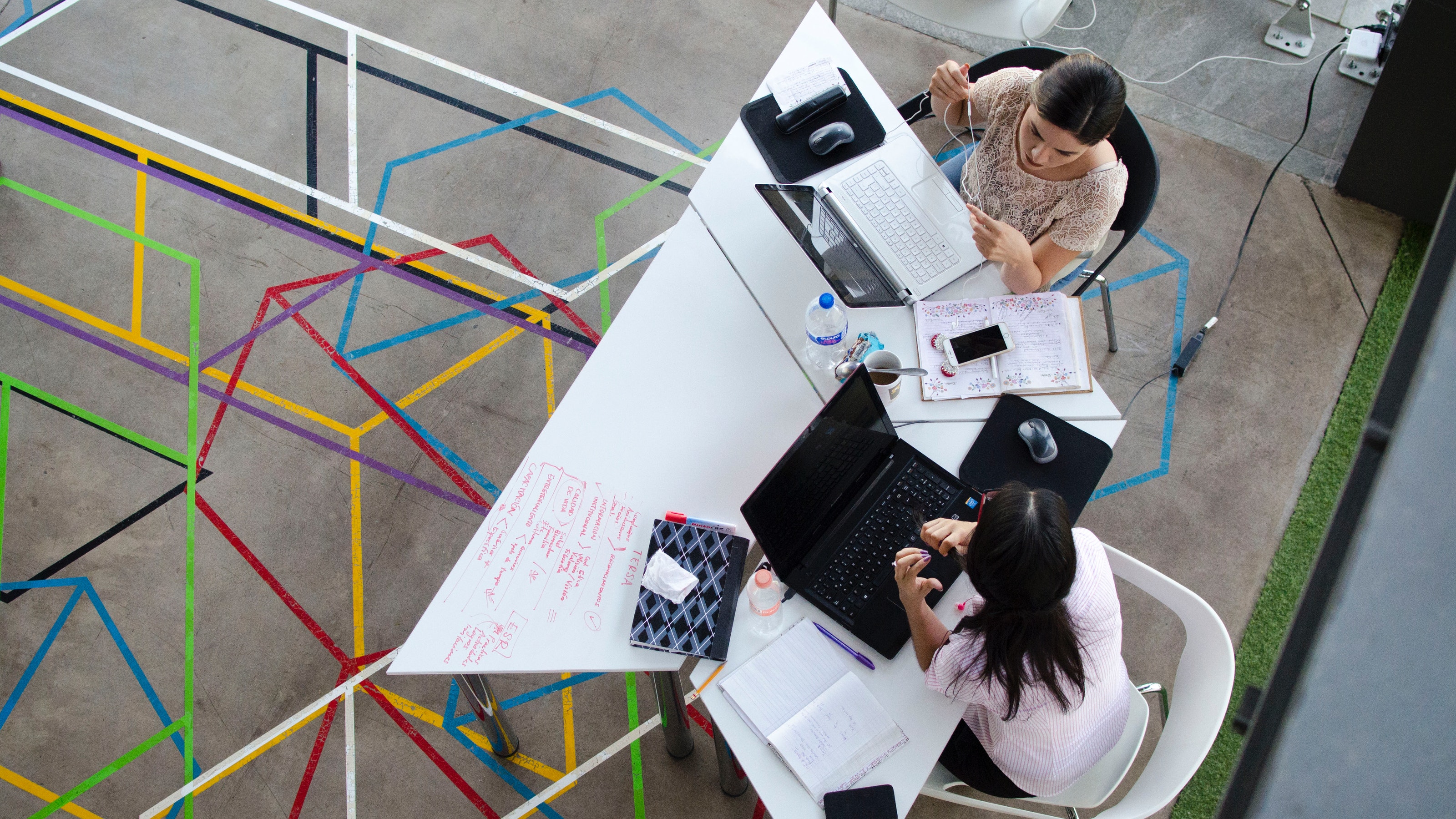 Two women working in a shared office space.
