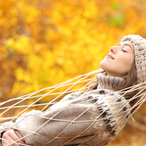 Woman sleeping on hammock in a forest in autumn