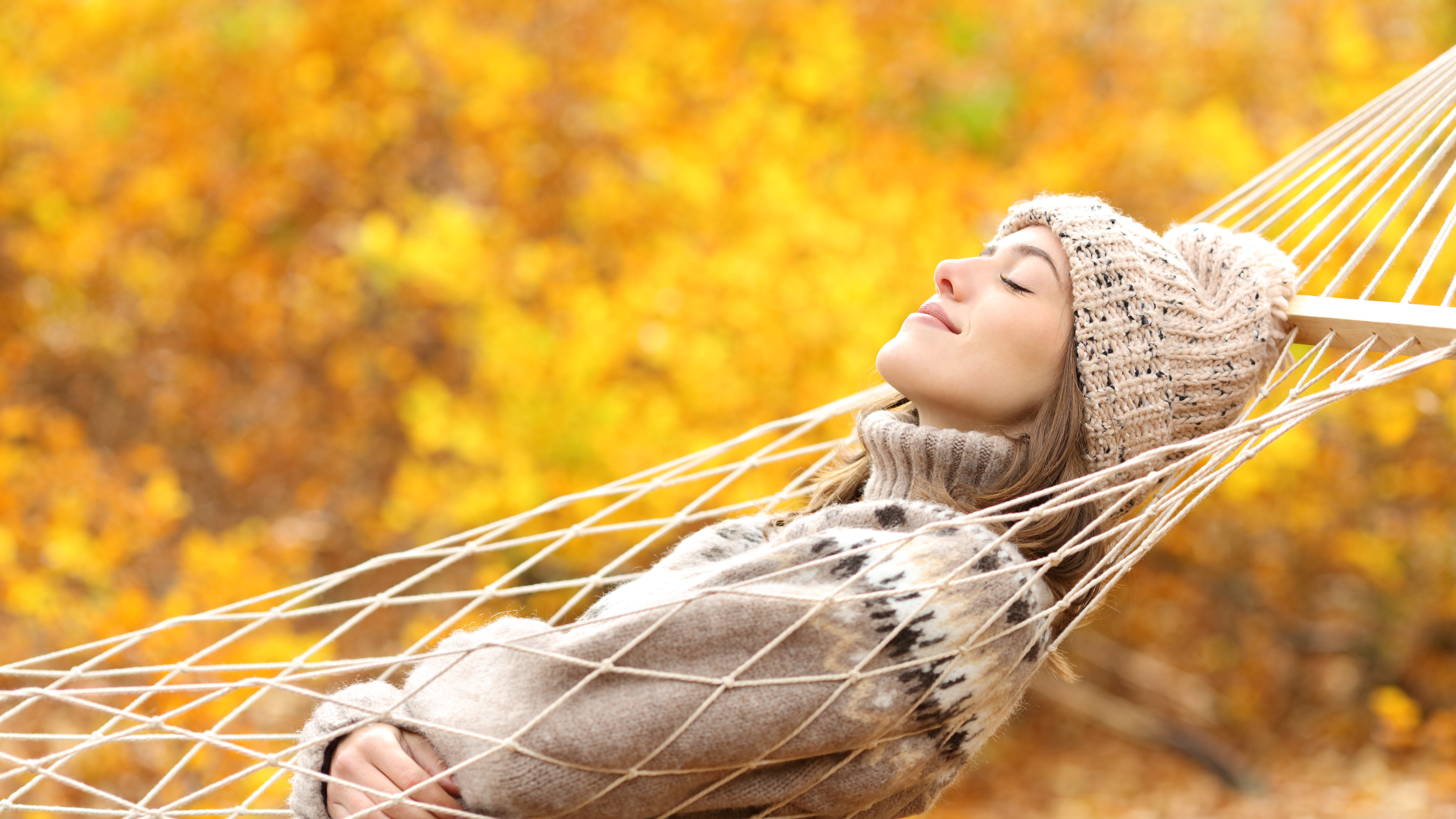 Woman sleeping on hammock in a forest in autumn