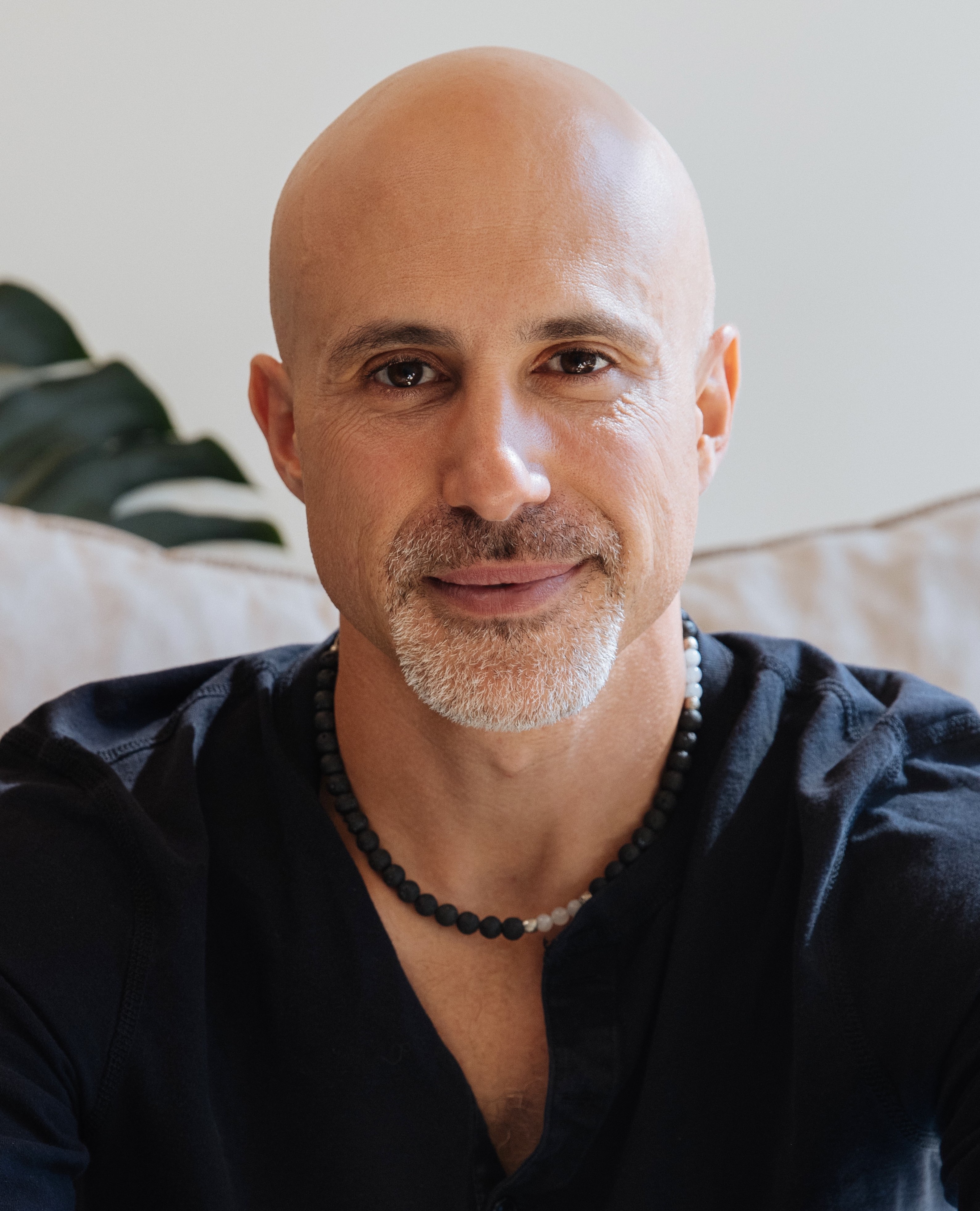 a man with a bald head wearing a black shirt.