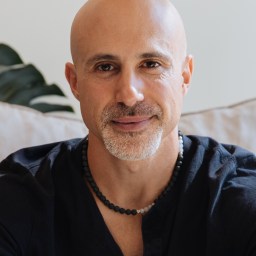 a man with a bald head wearing a black shirt.