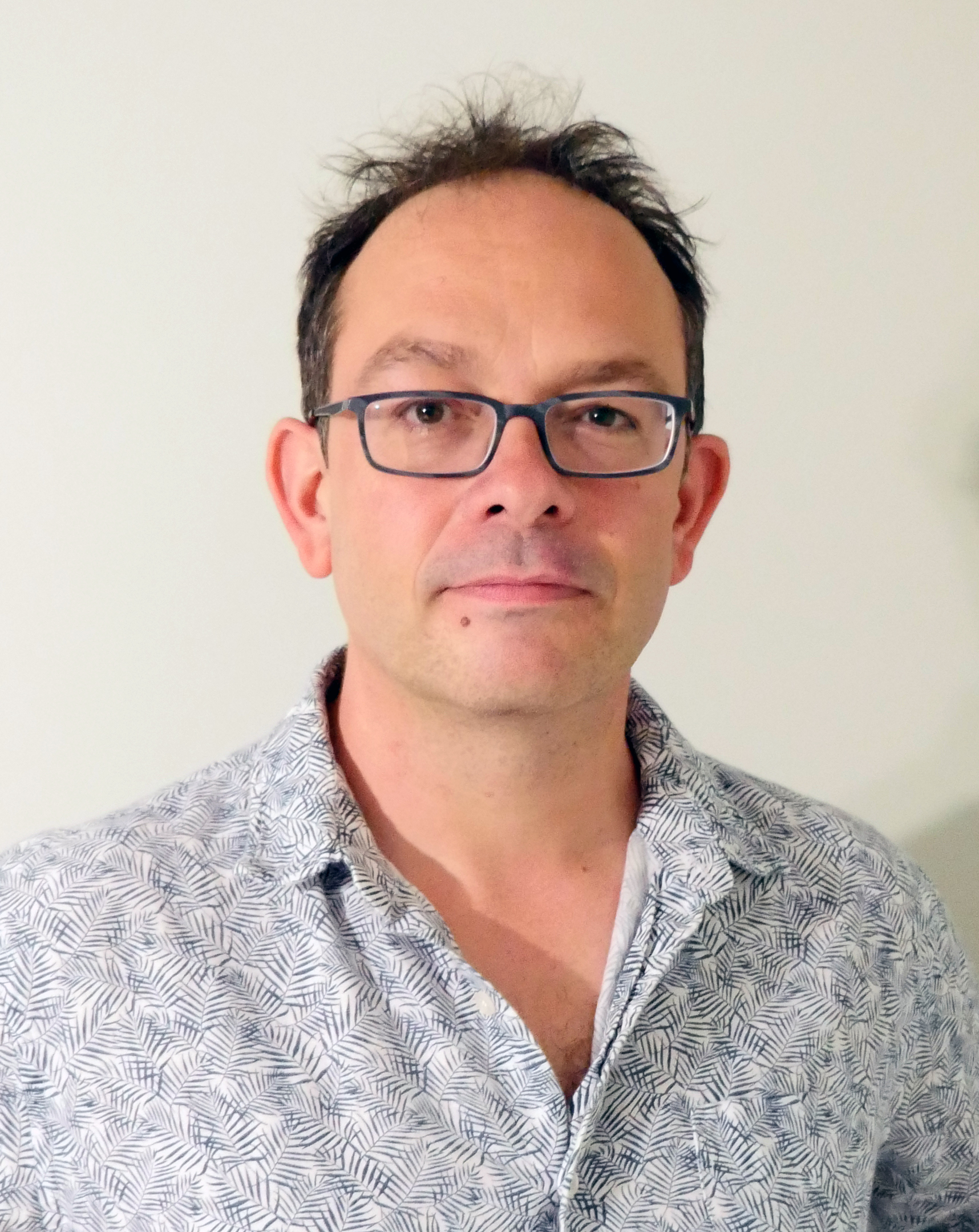 a man wearing glasses and a blue shirt.