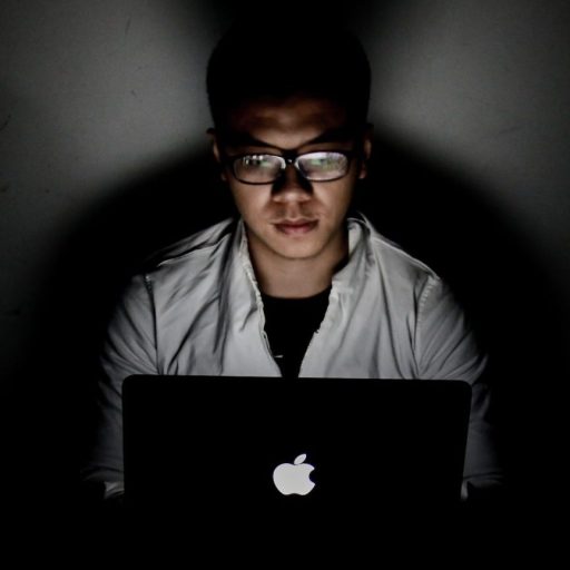a man sitting in front of a laptop computer.