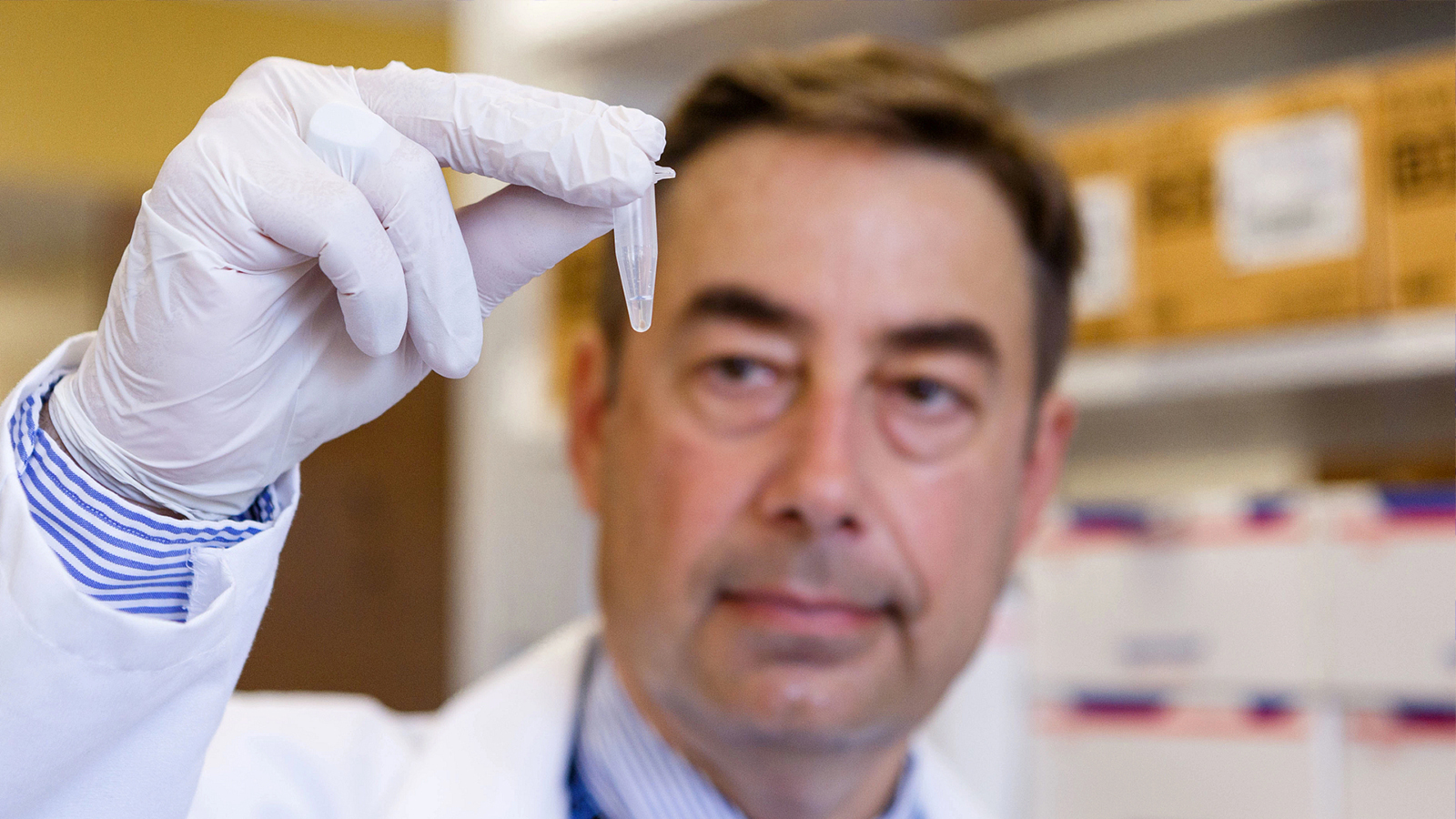 a man in a lab coat holding a test tube