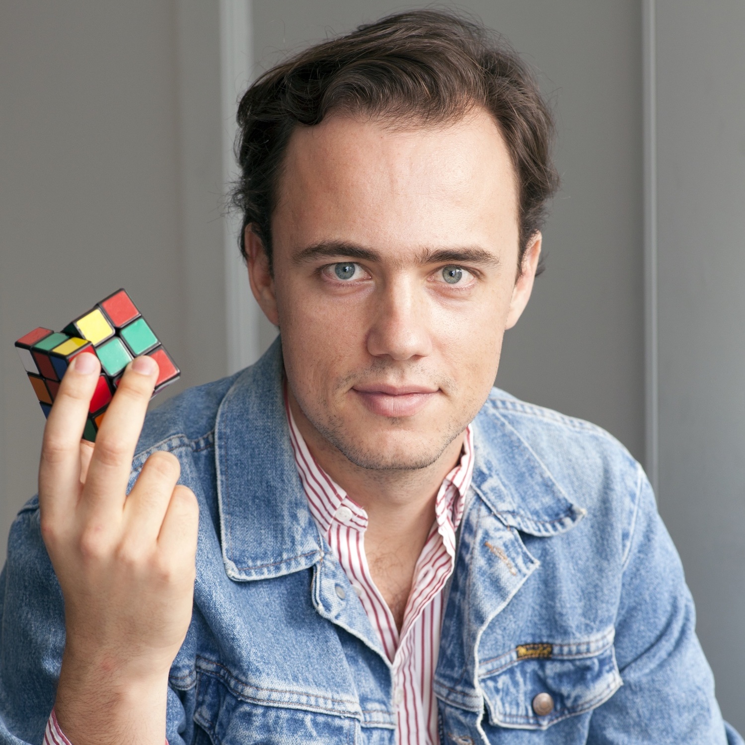 a man holding a rubik cube in his hand.