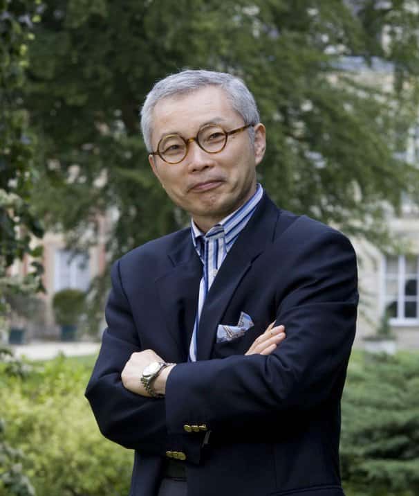 a man in a suit and tie standing with his arms crossed.