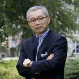 a man in a suit and tie standing with his arms crossed.