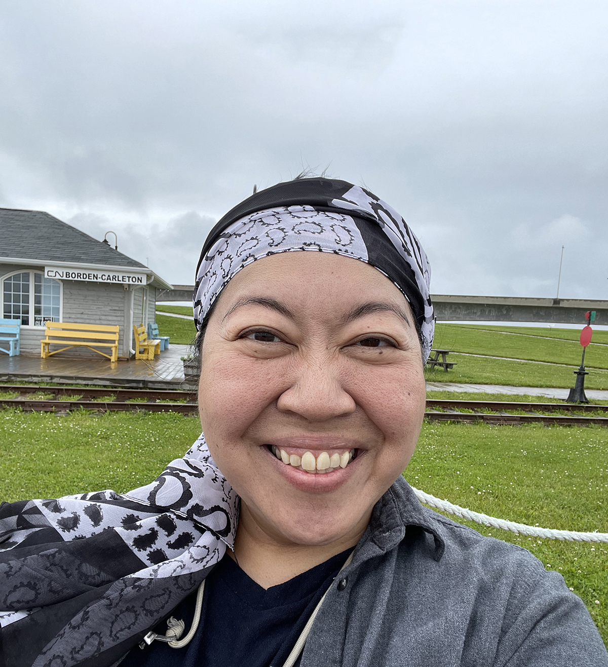 a woman wearing a bandana smiles for the camera.