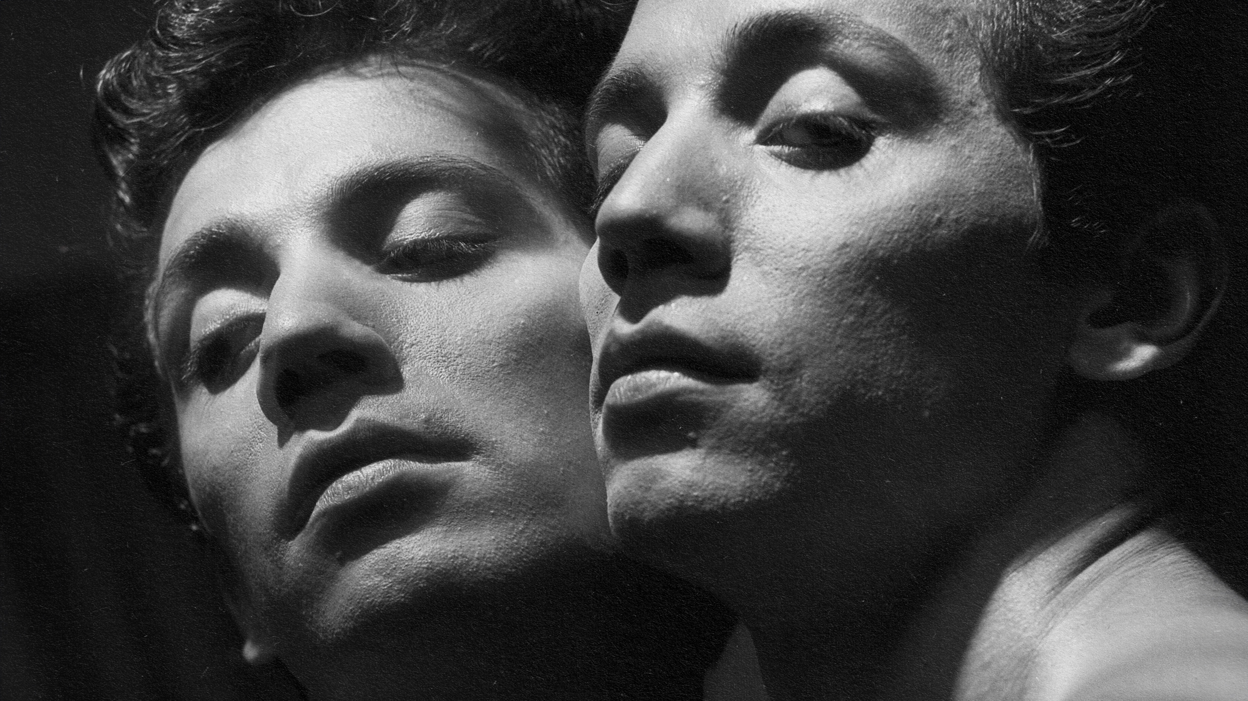 A black and white photo featuring two men engaged in a profound gaze.