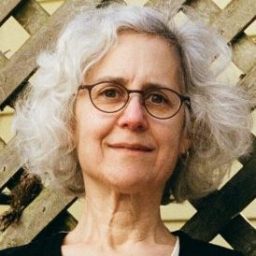 a woman wearing glasses and a black top.