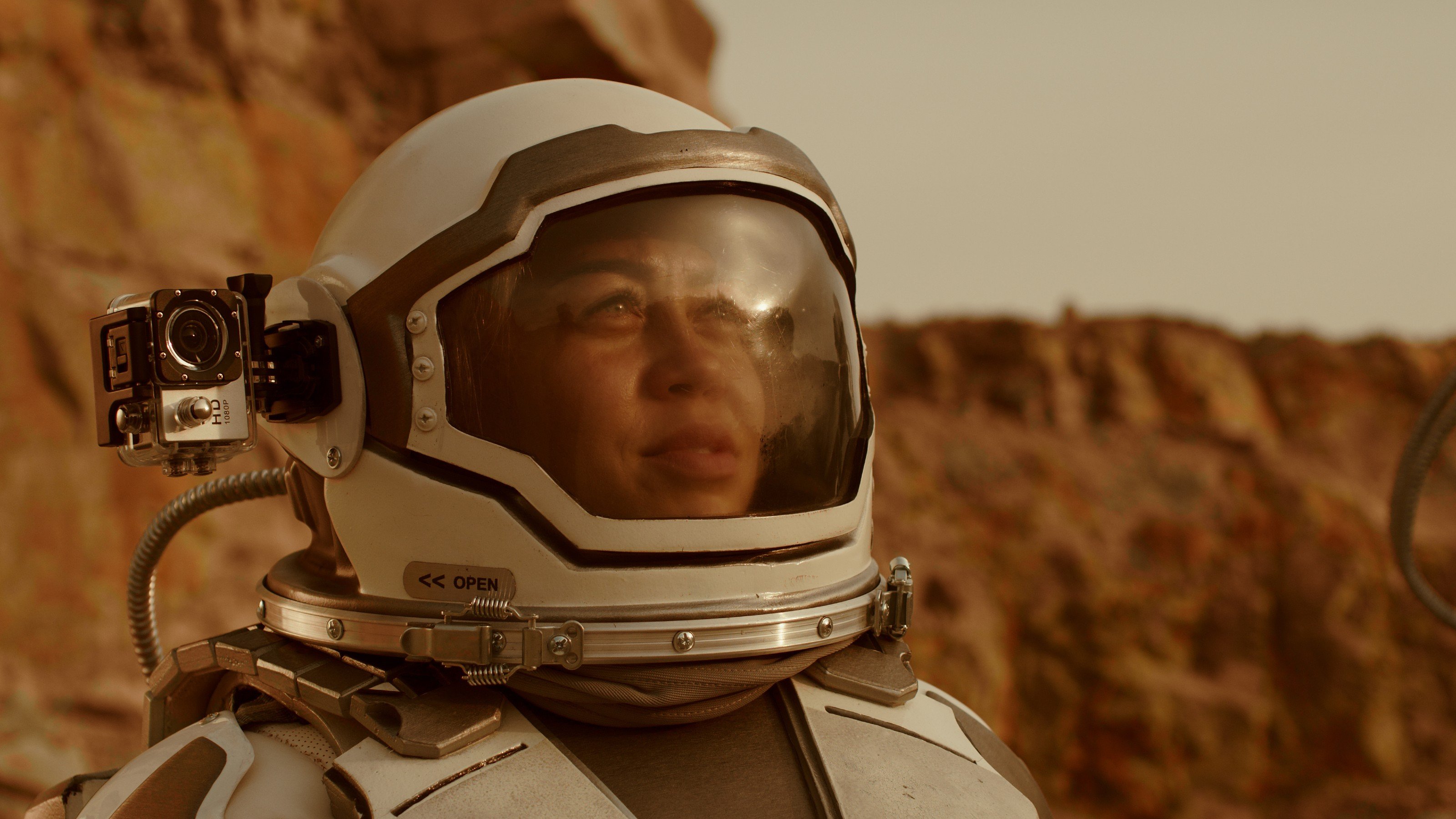 a man in a space suit with a camera in his hand.