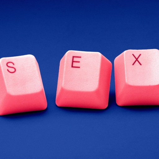 a pink computer keyboard with the word sex spelled on it.