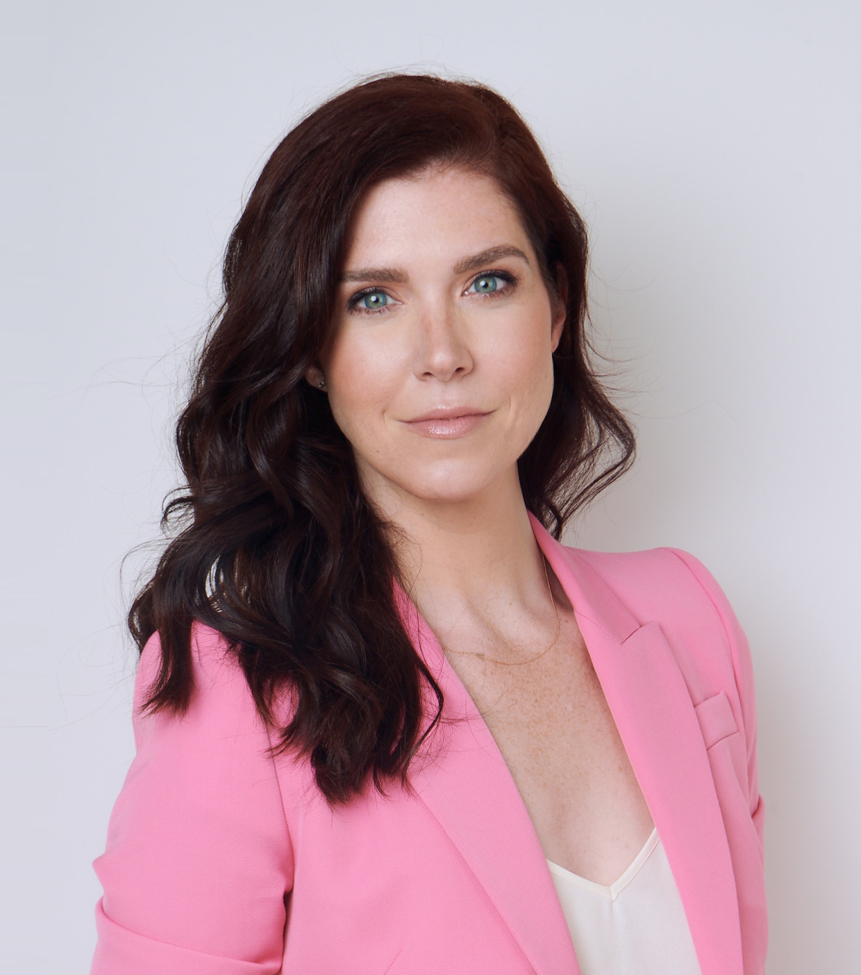 a woman in a pink suit posing for a picture.