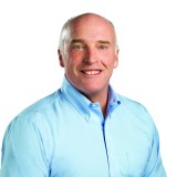 a man in a blue shirt is smiling.