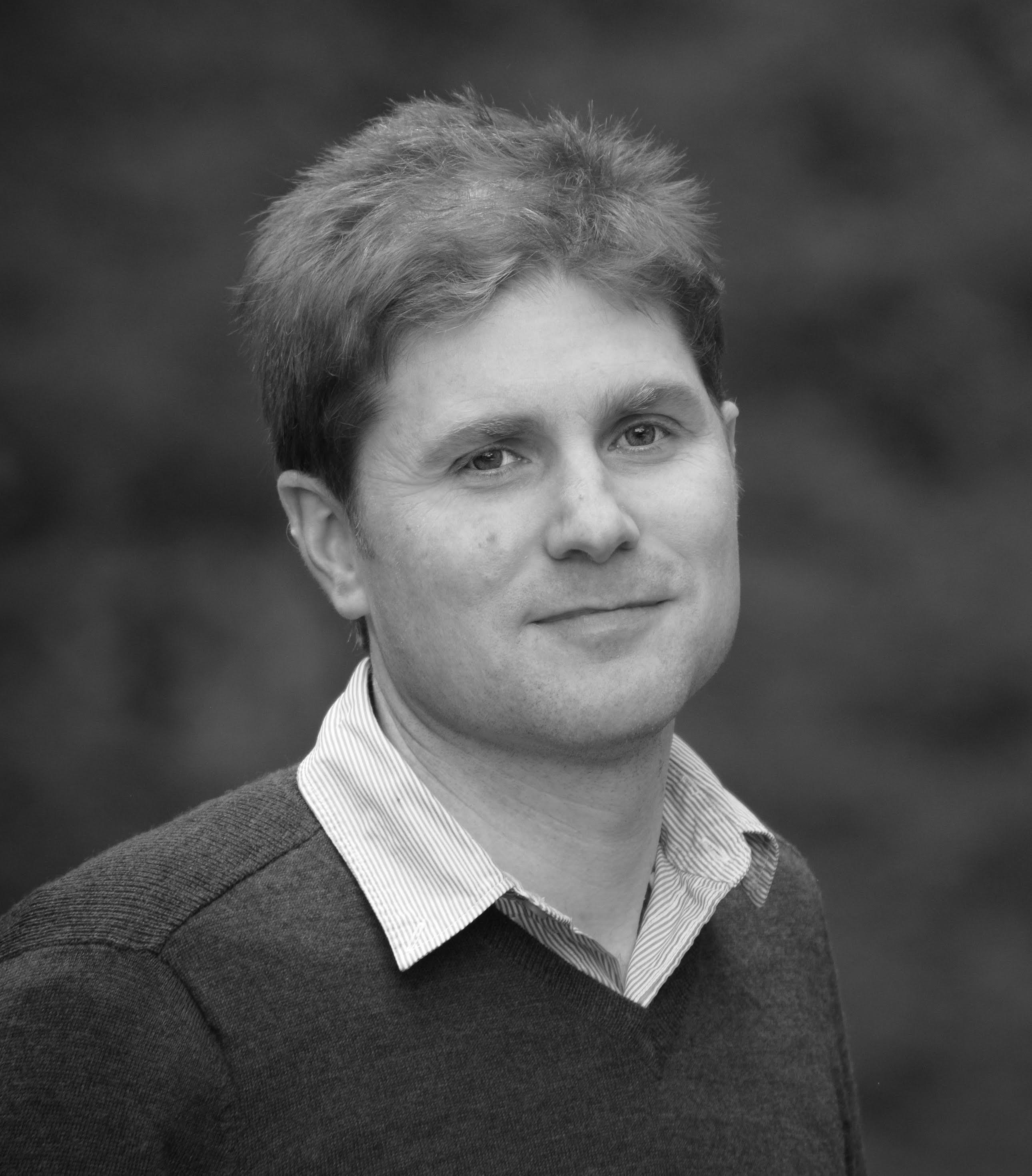a black and white photo of a man in a sweater.