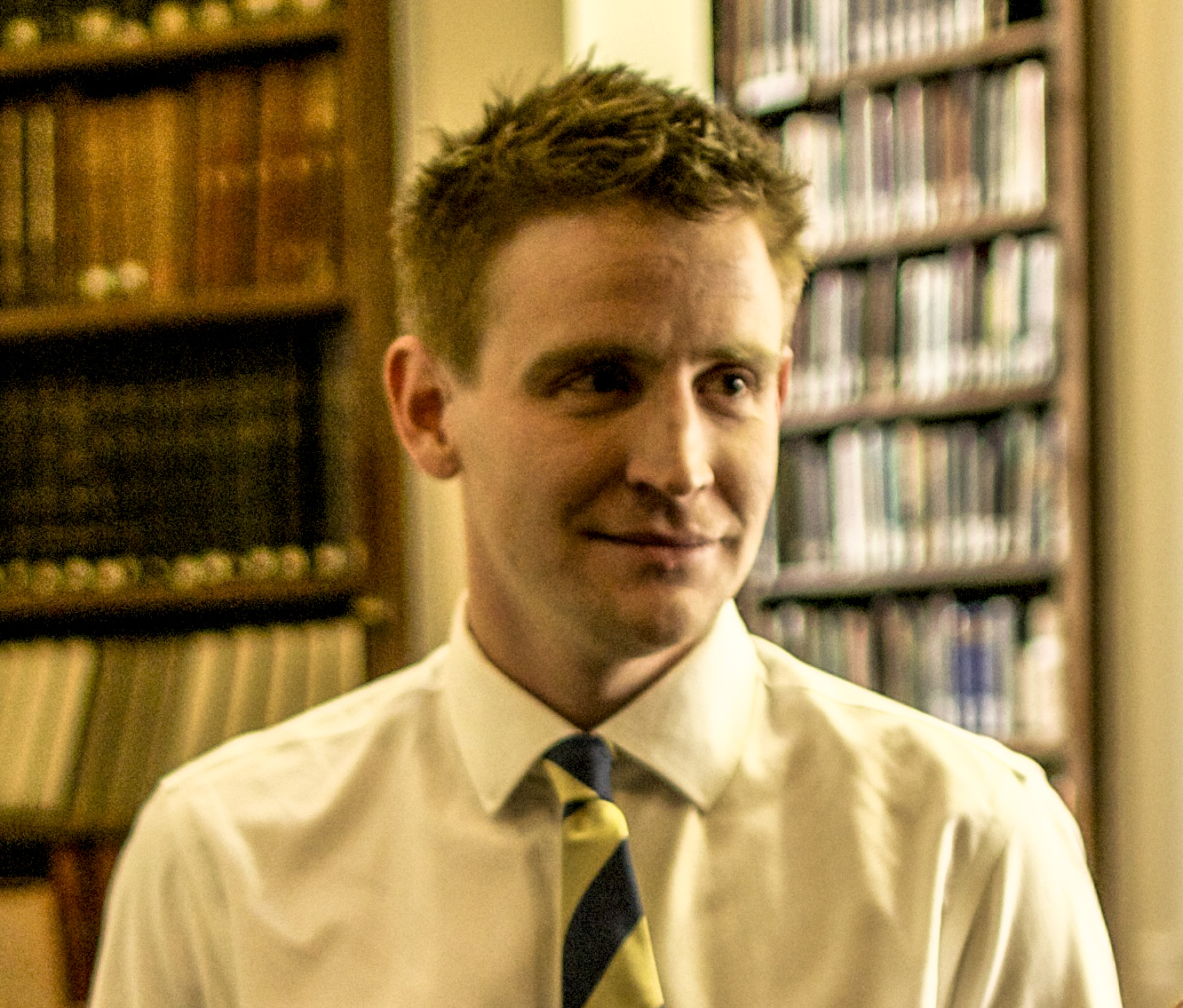 a man in a white shirt and yellow tie.