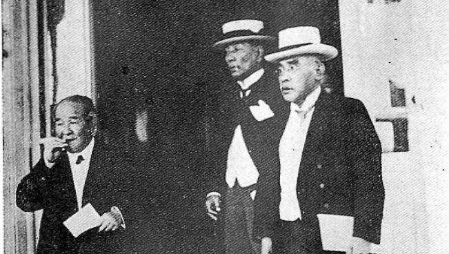 A group of men standing next to each other in front of a door.