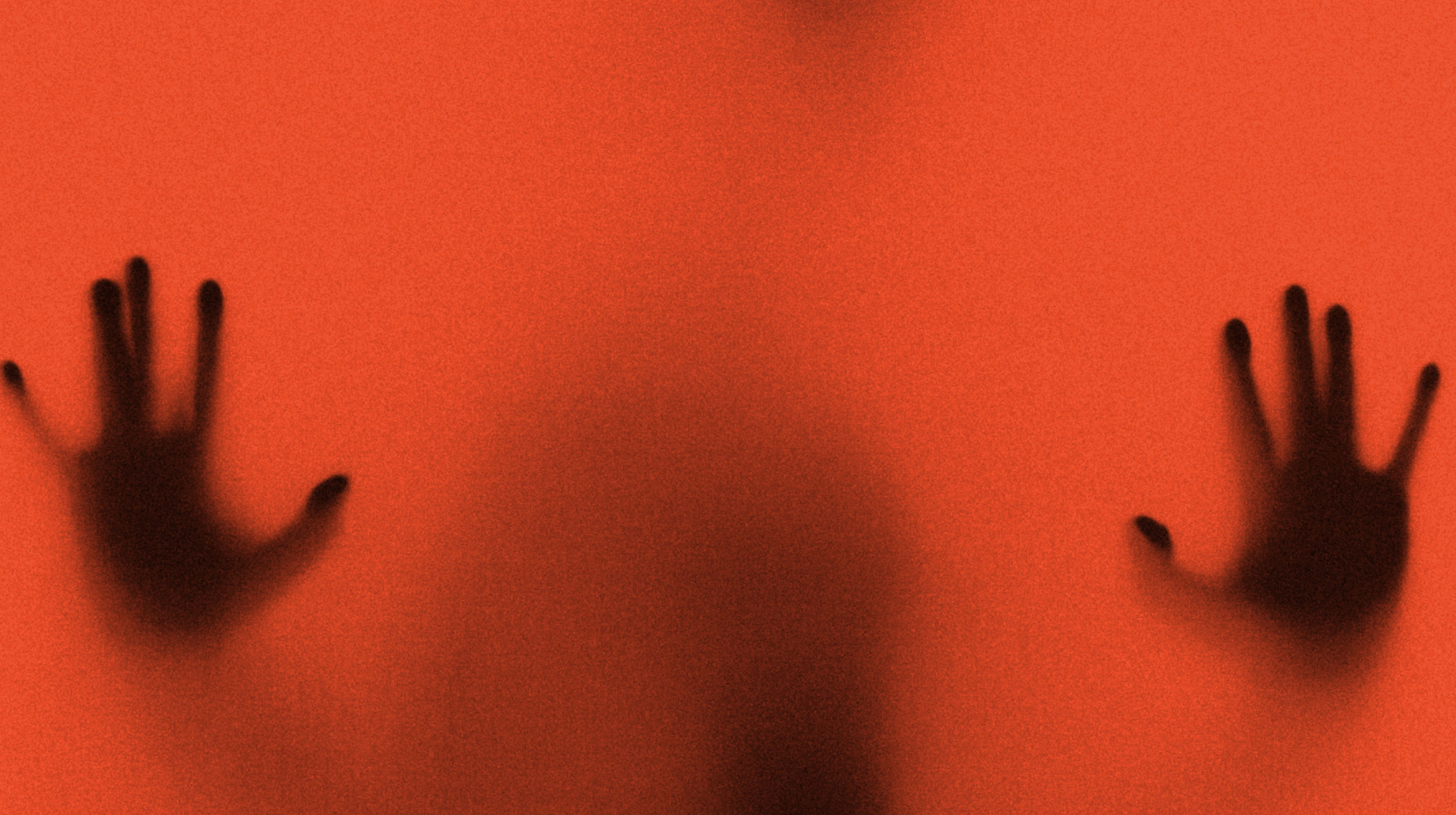 Silhouette of a person with outstretched hands pressed against a red, translucent surface.