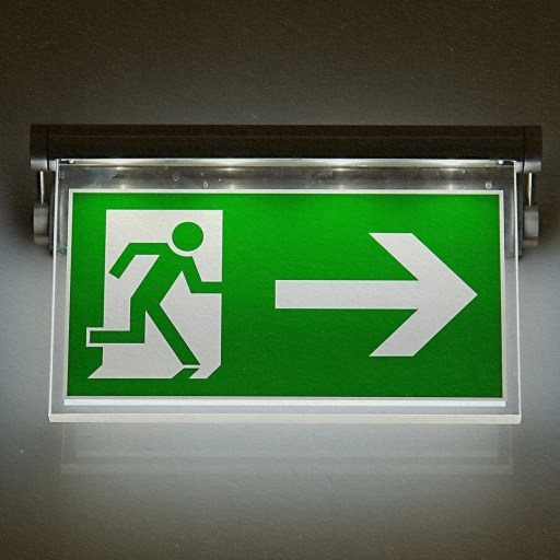 A green exit sign displaying a directional arrow.