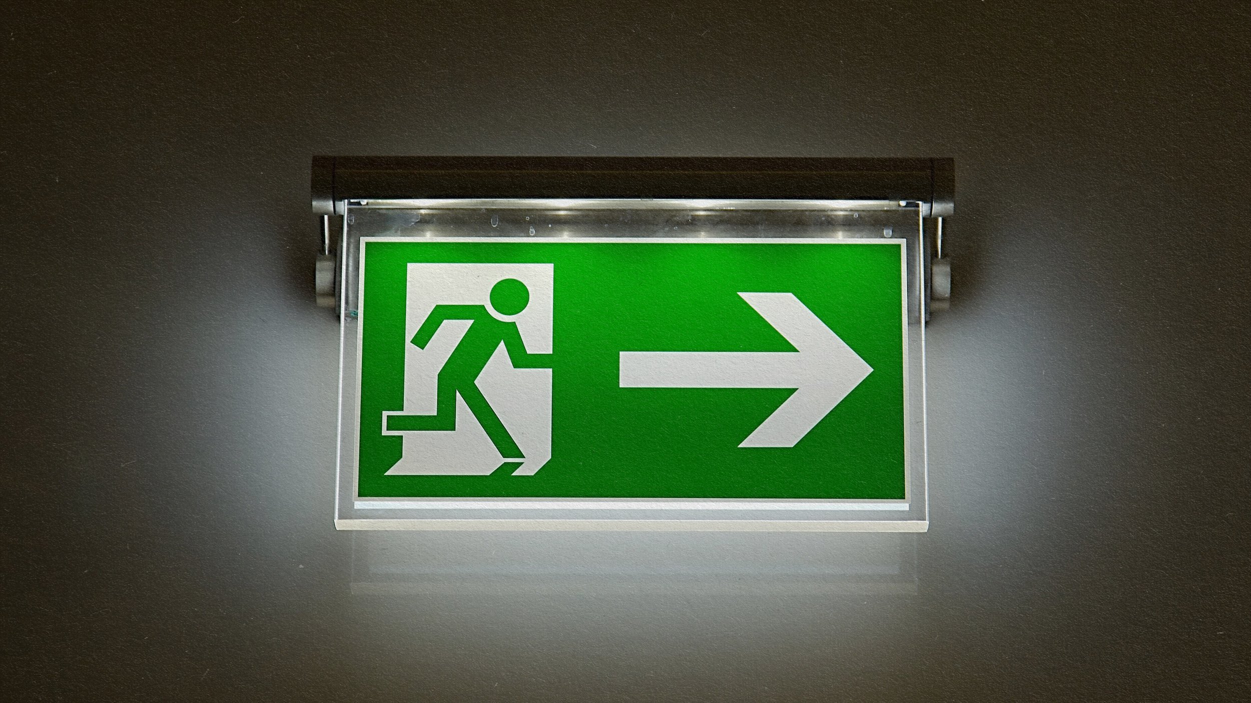 A green exit sign displaying a directional arrow.