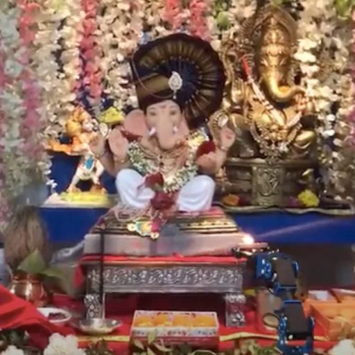 a statue of a person sitting in front of flowers.