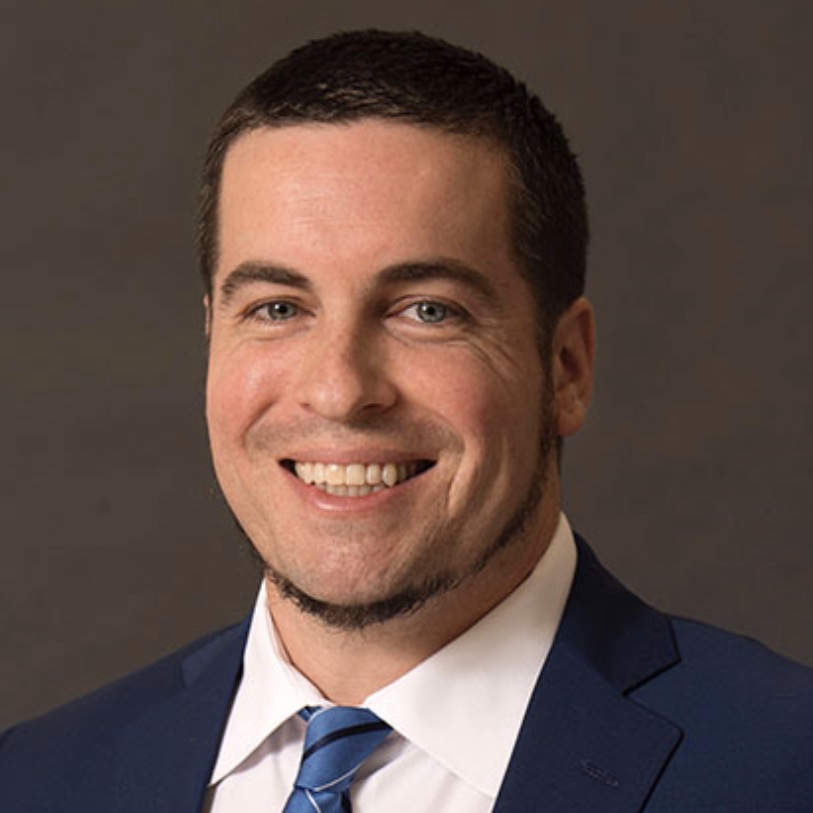 a man in a suit and tie smiling.