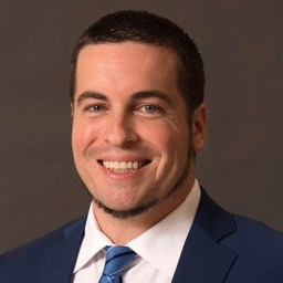 a man in a suit and tie smiling.